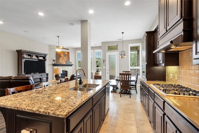 9012 Terrel St, Lantana, TX 76226 - kitchen with a sink, appliances with stainless steel finishes, a fireplace, dark brown cabinets, and ceiling fan