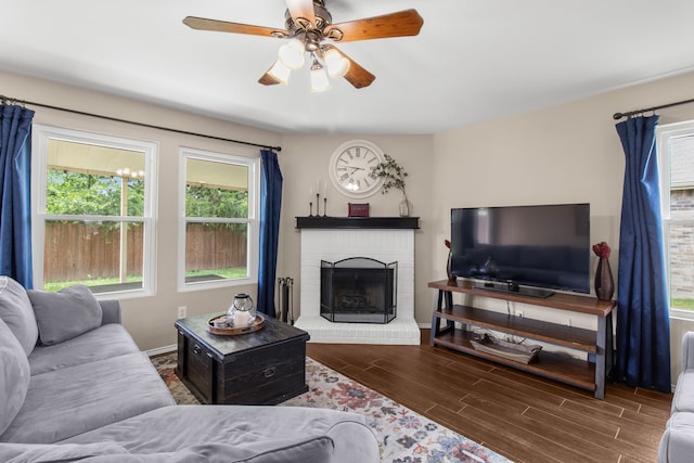 8308 Montecito Dr, Denton, TX 76210 - living room featuring ceiling fan, wood finished floors, a brick fireplace, and baseboards