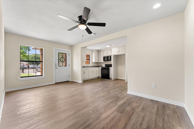 1008 Pleasant Dr, Dallas, TX 75217 - unfurnished living room with light wood-type flooring, baseboards, ceiling fan, and recessed lighting