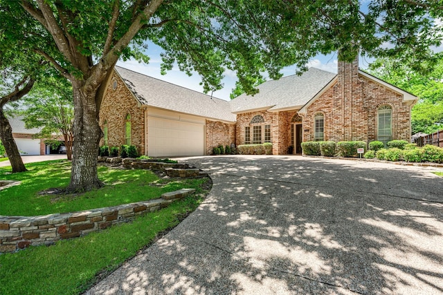 934 Hills Creek Dr, Mckinney, TX 75072 - view of front facade featuring brick siding, an attached garage, a chimney, concrete driveway, and roof with shingles