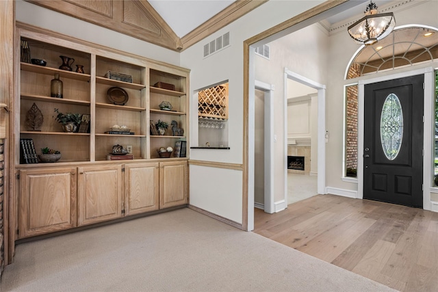 934 Hills Creek Dr, Mckinney, TX 75072 - foyer with a chandelier, vaulted ceiling, a fireplace, light wood finished floors, and baseboards