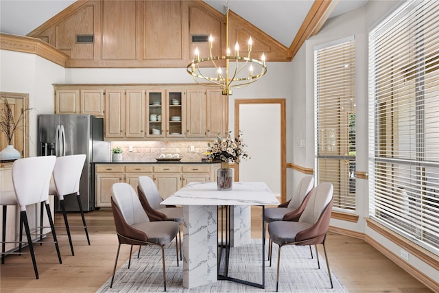 934 Hills Creek Dr, Mckinney, TX 75072 - dining area with a chandelier, light wood-style flooring, and high vaulted ceiling