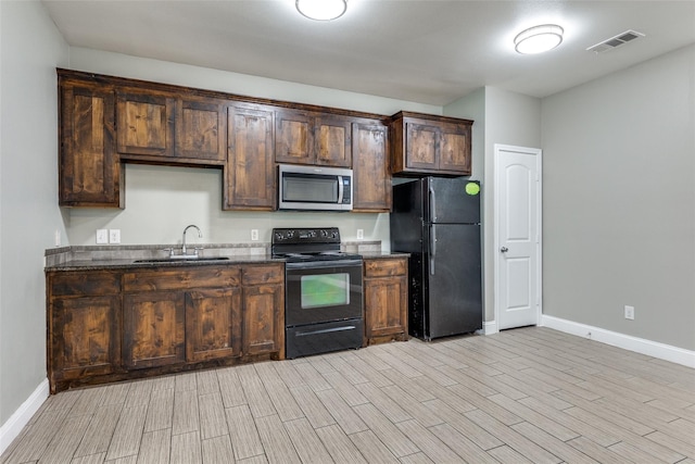 7418 Novella Dr, Fort Worth, TX 76134 - kitchen featuring black appliances, baseboards, light wood-type flooring, dark brown cabinetry, and a sink