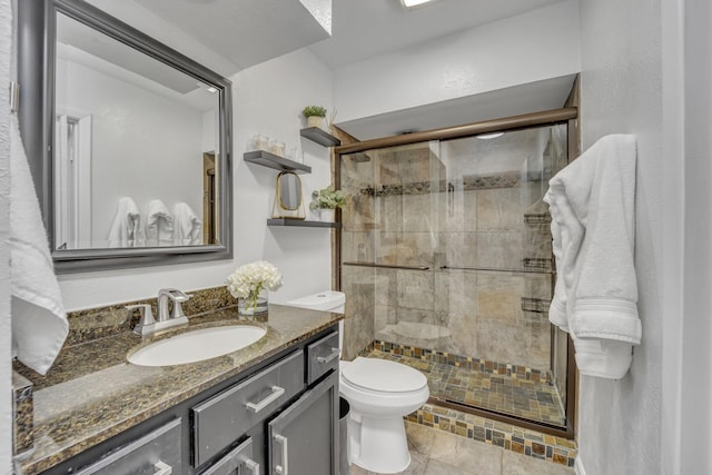 bathroom with a shower stall, toilet, and vanity
