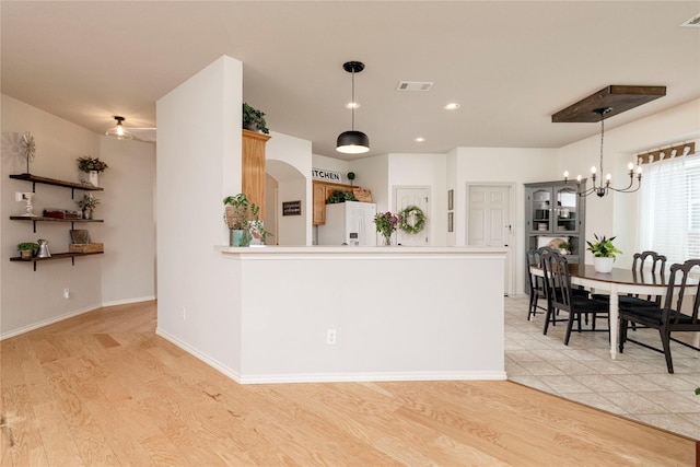 10617 Big Oak Dr, Fort Worth, TX 76131 - kitchen with white refrigerator with ice dispenser, a chandelier, light wood-style flooring, decorative light fixtures, and recessed lighting