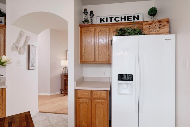 10617 Big Oak Dr, Fort Worth, TX 76131 - kitchen with white fridge with ice dispenser, light countertops, arched walkways, and baseboards