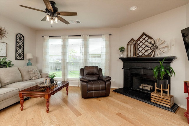 10617 Big Oak Dr, Fort Worth, TX 76131 - living room with wood finished floors, a ceiling fan, a fireplace with raised hearth, and baseboards