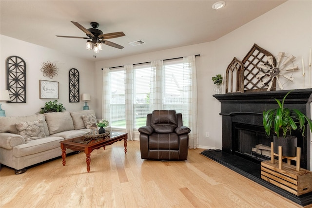 10617 Big Oak Dr, Fort Worth, TX 76131 - living area with wood finished floors, ceiling fan, a fireplace with raised hearth, and baseboards