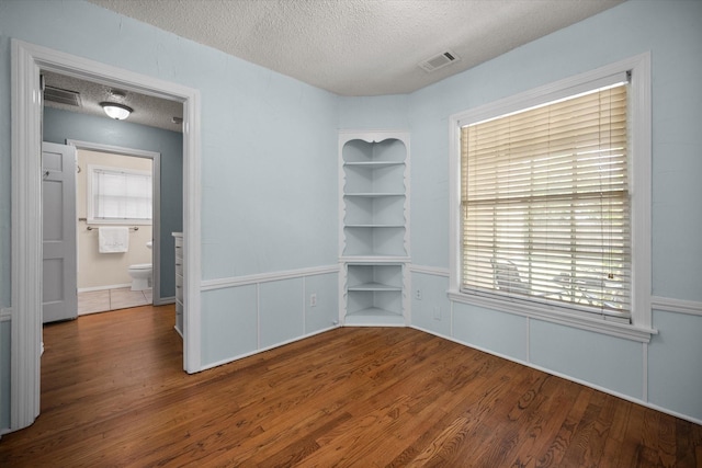 empty room featuring a textured ceiling and wood finished floors
