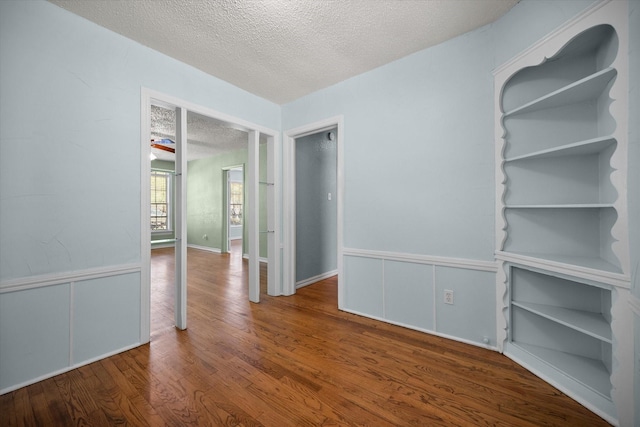 empty room featuring a textured ceiling and wood finished floors