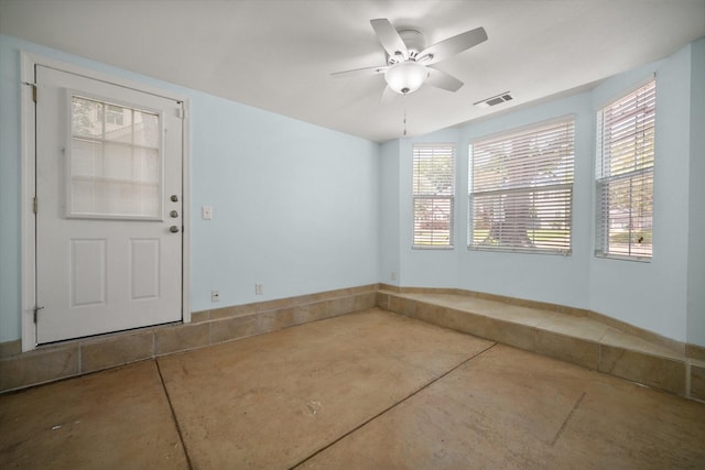 unfurnished room featuring concrete flooring, ceiling fan, and baseboards