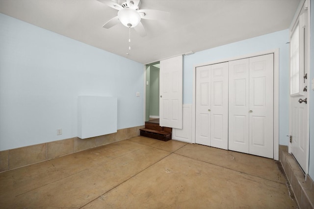 unfurnished bedroom with concrete flooring, a closet, and a ceiling fan