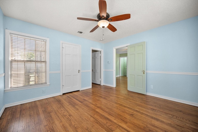 unfurnished bedroom with baseboards, wood finished floors, a textured ceiling, and ceiling fan