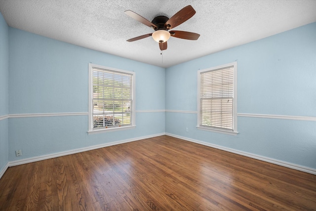 empty room with baseboards, wood finished floors, a ceiling fan, and a textured ceiling