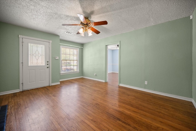 foyer entrance with ceiling fan, wood finished floors, a textured ceiling, and baseboards