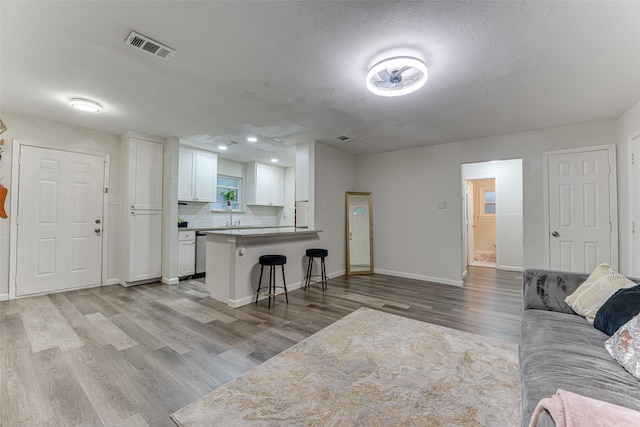 3444 Kellogg Ave, Dallas, TX 75216 - living area with wood finished floors, baseboards, a textured ceiling, and recessed lighting
