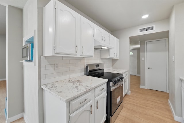 2833 Miller Pl, Mesquite, TX 75150 - kitchen featuring stainless steel range with electric stovetop, under cabinet range hood, white cabinetry, light wood-style flooring, and recessed lighting