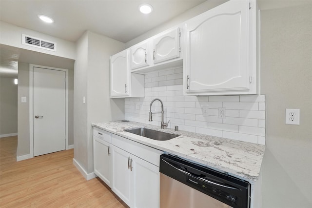 2833 Miller Pl, Mesquite, TX 75150 - kitchen with stainless steel dishwasher, a sink, white cabinetry, light stone counters, and backsplash