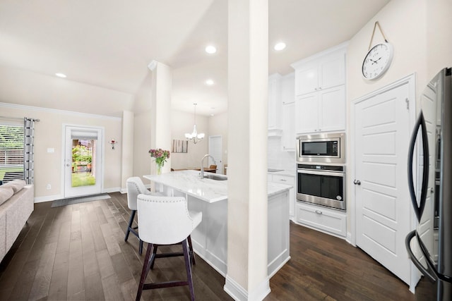 481 Washington Ave, Waxahachie, TX 75165 - kitchen featuring stainless steel appliances, a sink, light stone counters, dark wood-style flooring, and a kitchen breakfast bar