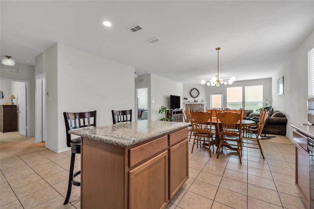 2336 Bermont Red Ln, Fort Worth, TX 76131 - kitchen with open floor plan, light tile patterned floors, a center island, a chandelier, and a kitchen bar