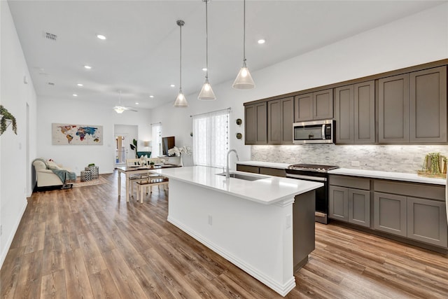 1413 Horizon Way, Northlake, TX 76247 - kitchen featuring stainless steel appliances, a sink, decorative backsplash, open floor plan, and light countertops