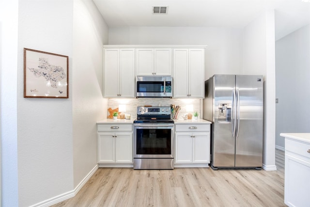 2836 Dawn Spring Dr, Little Elm, TX 75068 - kitchen with appliances with stainless steel finishes, light wood-style floors, white cabinetry, and light countertops