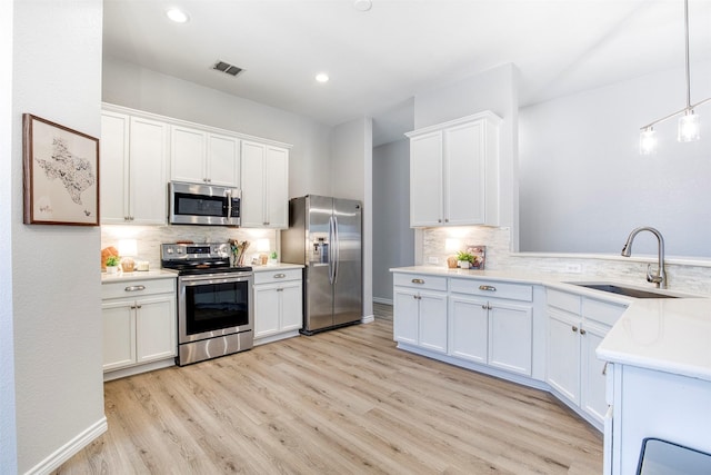 2836 Dawn Spring Dr, Little Elm, TX 75068 - kitchen with stainless steel appliances, a sink, tasteful backsplash, light wood-style flooring, and light countertops