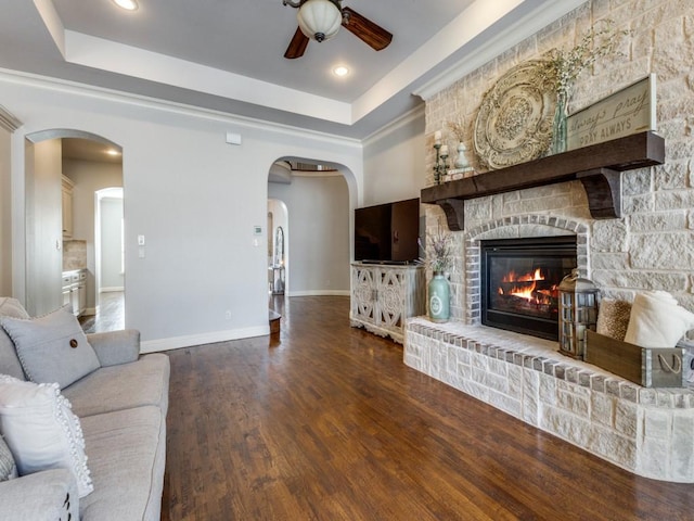 114 Crestbrook Dr, Rockwall, TX 75087 - living area with ceiling fan, a raised ceiling, a fireplace, baseboards, and wood finished floors