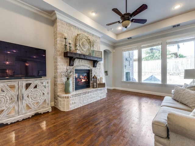 114 Crestbrook Dr, Rockwall, TX 75087 - living area featuring a fireplace, a ceiling fan, dark wood-style flooring, ornamental molding, and healthy amount of natural light