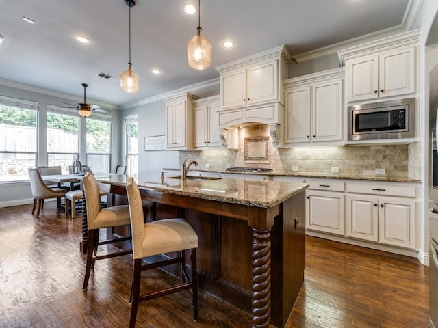 114 Crestbrook Dr, Rockwall, TX 75087 - kitchen featuring appliances with stainless steel finishes, crown molding, a sink, light stone counters, and backsplash