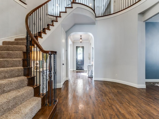 114 Crestbrook Dr, Rockwall, TX 75087 - foyer entrance with arched walkways, wood finished floors, stairway, a towering ceiling, and baseboards