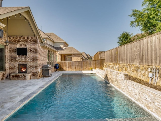 114 Crestbrook Dr, Rockwall, TX 75087 - view of pool featuring an outdoor brick fireplace, a patio, a fenced backyard, and area for grilling
