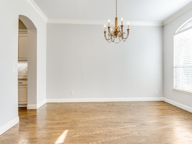 114 Crestbrook Dr, Rockwall, TX 75087 - empty room featuring light wood-style floors, a chandelier, arched walkways, crown molding, and baseboards