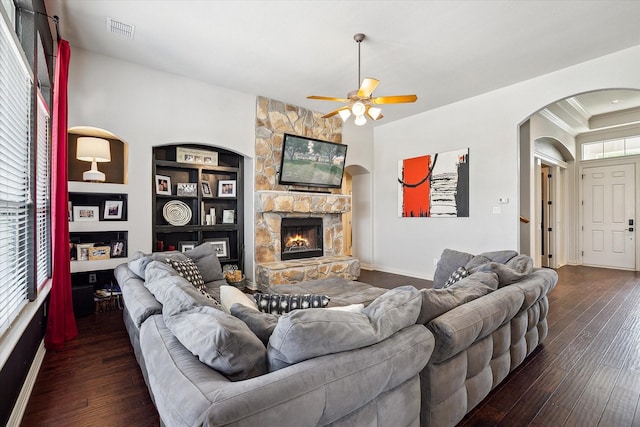 10601 Los Rios Dr, Fort Worth, TX 76179 - living area featuring arched walkways, a ceiling fan, dark wood-style floors, a stone fireplace, and baseboards