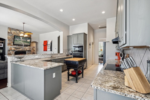 10601 Los Rios Dr, Fort Worth, TX 76179 - kitchen featuring gray cabinets, black appliances, a sink, a peninsula, and arched walkways