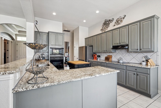 10601 Los Rios Dr, Fort Worth, TX 76179 - kitchen with gray cabinetry, black appliances, under cabinet range hood, and recessed lighting