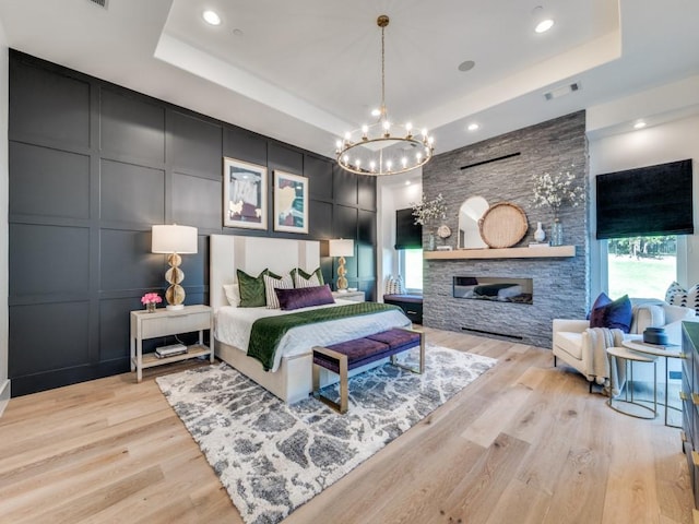 620 Redwood Creek Dr, Fairview, TX 75069 - bedroom with a tray ceiling, a decorative wall, a chandelier, light wood-type flooring, and recessed lighting