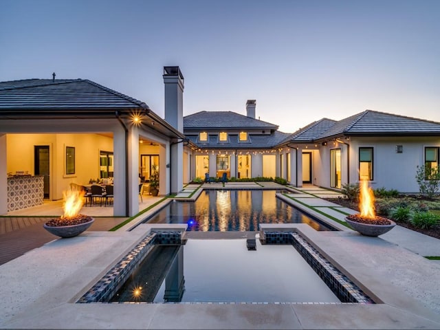 620 Redwood Creek Dr, Fairview, TX 75069 - rear view of house featuring an outdoor fire pit, a patio, a pool with connected hot tub, and a chimney