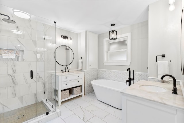 9031 Fringewood Dr, Dallas, TX 75228 - full bathroom featuring a stall shower, marble finish flooring, a freestanding bath, tile walls, and two vanities