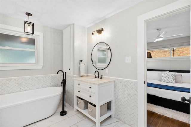 9031 Fringewood Dr, Dallas, TX 75228 - full bathroom with wainscoting, tile walls, ensuite bath, vanity, and a soaking tub