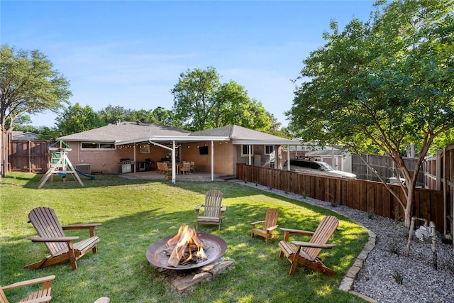 9031 Fringewood Dr, Dallas, TX 75228 - back of house with a fire pit, a patio, a playground, and brick siding