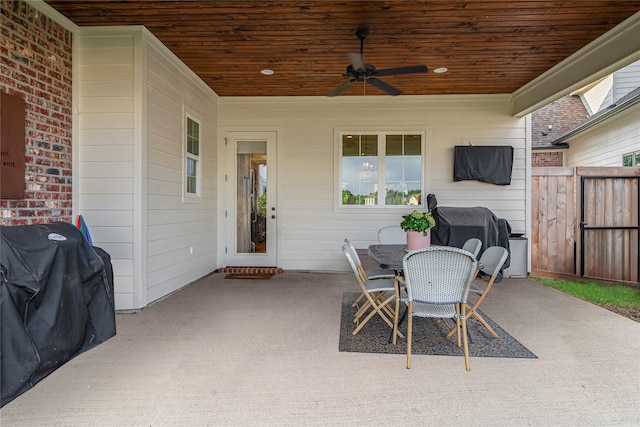 view of patio with a ceiling fan, fence, and outdoor dining space