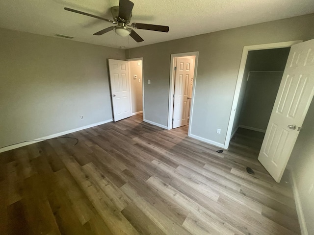 236 Ezekial Ave, Dallas, TX 75217 - unfurnished bedroom with a spacious closet, baseboards, wood finished floors, a closet, and ceiling fan
