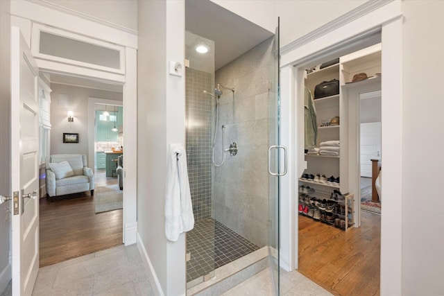 404 E Wall St, Grapevine, TX 76051 - bathroom with a stall shower, ensuite bath, a spacious closet, wood finished floors, and baseboards