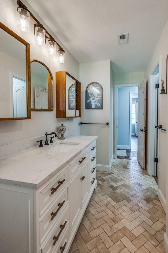 309 Westpark Dr N, Mckinney, TX 75071 - bathroom featuring vanity, baseboards, and brick flooring