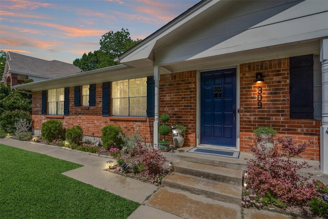 309 Westpark Dr N, Mckinney, TX 75071 - exterior entry at dusk featuring brick siding and a lawn