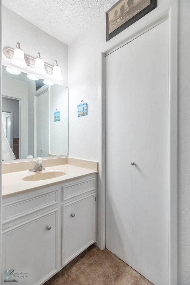 1001 Chriswood Dr, Abilene, TX 79601 - bathroom featuring a textured ceiling and vanity