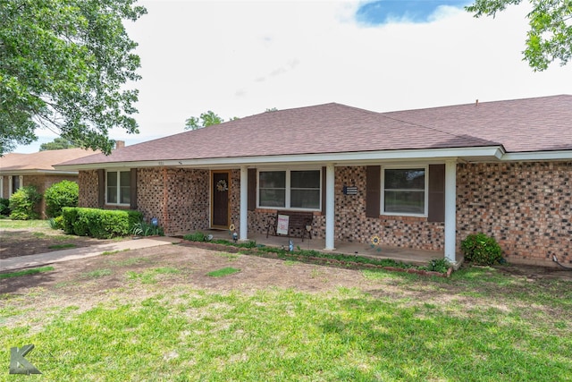 1001 Chriswood Dr, Abilene, TX 79601 - ranch-style home with brick siding, a porch, roof with shingles, and a front lawn