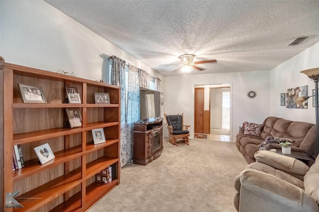 1001 Chriswood Dr, Abilene, TX 79601 - living room featuring a textured ceiling, light colored carpet, ceiling fan, and healthy amount of natural light