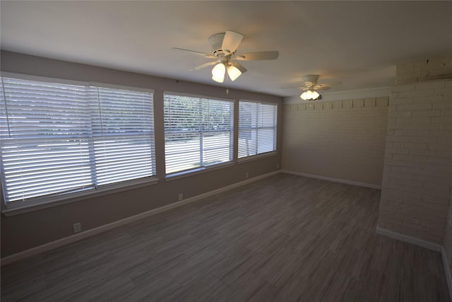 7921 Oak Pkwy, Burleson, TX 76028 - unfurnished room featuring brick wall, baseboards, a ceiling fan, and wood finished floors
